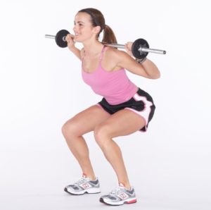 Woman doing squat exercise with barbell